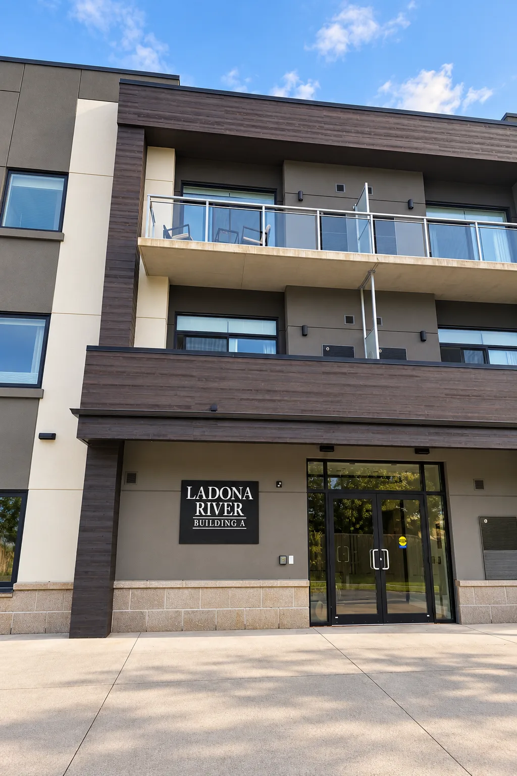 Ladona River Apartments entry with StoCast Wood faux wood on the canopy, balcony band, and column beside gray and cream EIFS