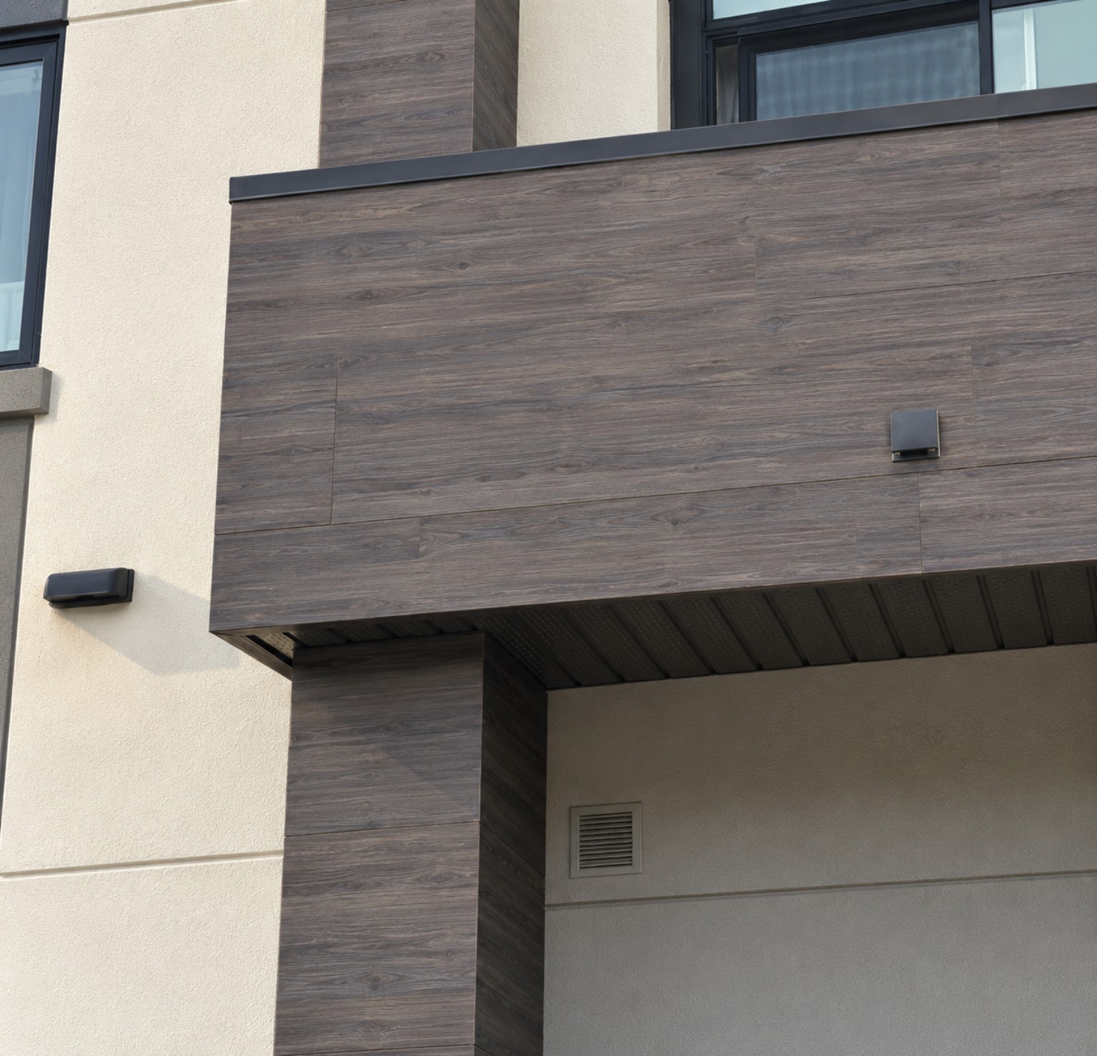 Dark faux wood finish detail on an EIFS and stucco exterior